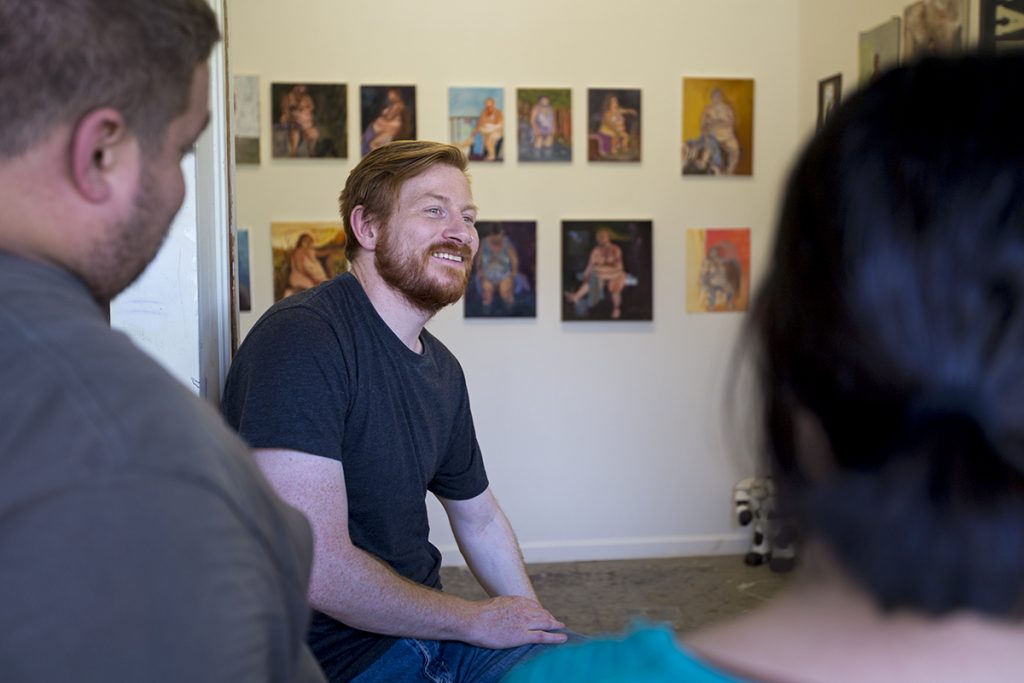 School of Art student David Dupak chats with other art students in front of Gallery 11 where some of his paintings are displayed Monday, July 11, 2016, at the School of Art.