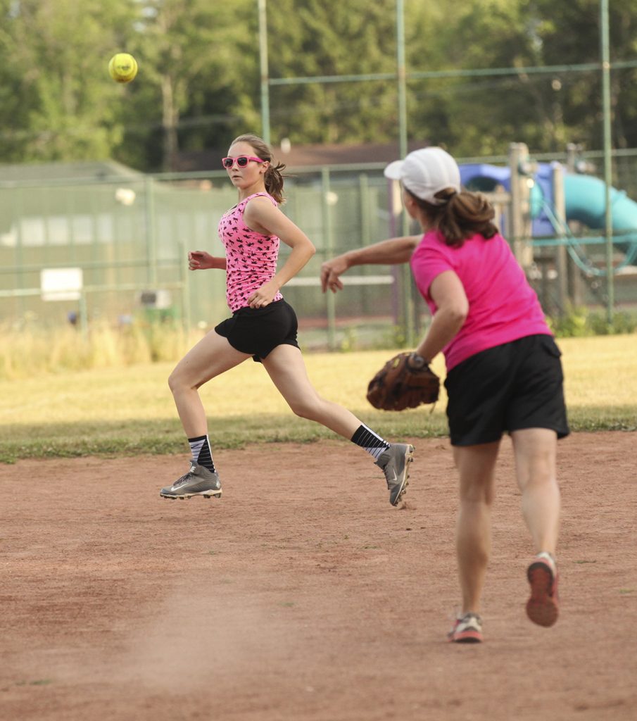 Taylor Samuelson, of the Hot Chauts team, left, runs to third base as Mary Pat McFarland, of the Chautauqua Belles team, right, throws the ball at 7 P.M. on Tuesday, July 26, 2016, at Sharpe Field. The Hot Chauts, who won the game, also ultimately won first place in the women's league, defeating the Misfits by one run in extra innings. Photo by Carolyn Brown.