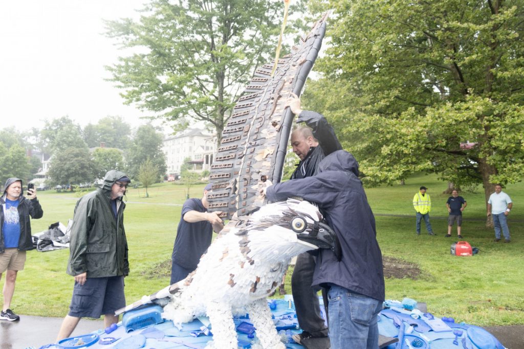 Steve Wright, an artist with Washed Ashore — Art to Save the Sea, guides a wing of the new osprey statue into place Thursday morning on the Athenaeum Hotel lawn, near Sports Club.