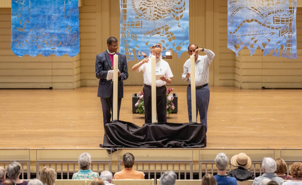From left, the Rt. Rev. Eugene T. Sutton, senior pastor of Chautauqua Institution; Joe Lewis, co-host of the Everett Jewish Life Center; and Khalid Rehman, longtime Chautauquan and instructor of the “Islam 101” courses, light candles during a Sacred Song Service dedicated to the Abrahamic religions on Sunday, July 16, 2023, in the Amphitheater.